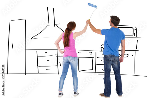Couple painting a wall together against kitchen sketch