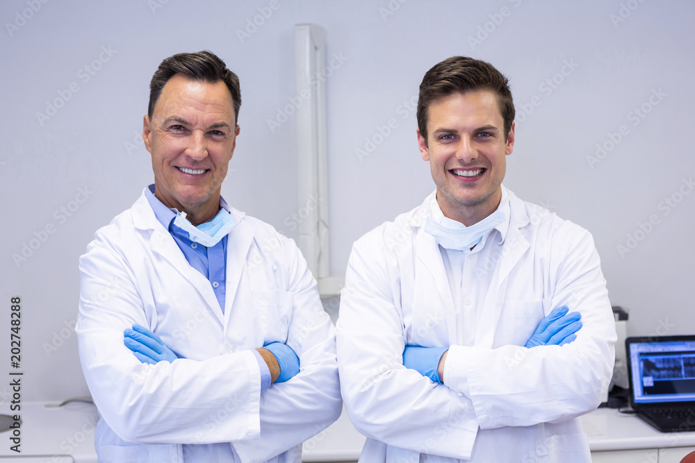 Portrait of happy dentists standing with arms crossed Portrait of happy dentists standing with arms crossed