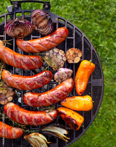 Grilled sausages and vegetables on a grilled plate, outdoor, top view. Grilled food, bbq