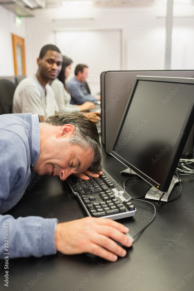Man taking nap at computer class Man taking nap at computer class