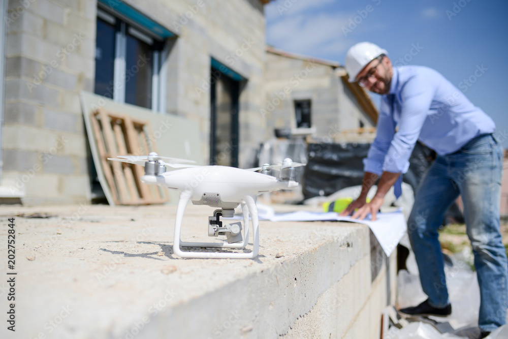 handsome architect flying inspection drone for aerial view of a house construction site industry handsome architect flying inspection drone for aerial view of a house construction site industry