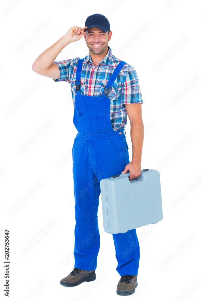 Happy manual worker wearing cap while carrying toolbox Happy manual worker wearing cap while carrying toolbox