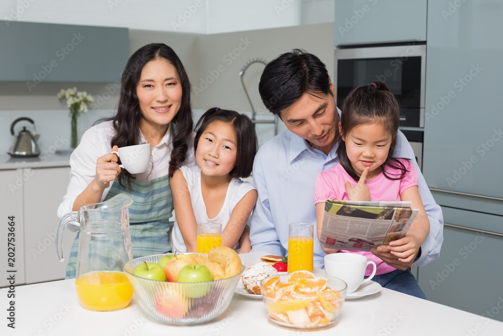 Family of four enjoying healthy breakfast in kitchen Family of four enjoying healthy breakfast in kitchen