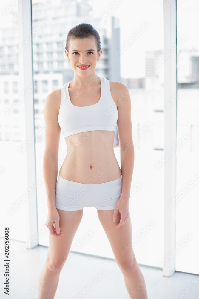 Lovely fit brown haired model in sportswear posing looking at camera