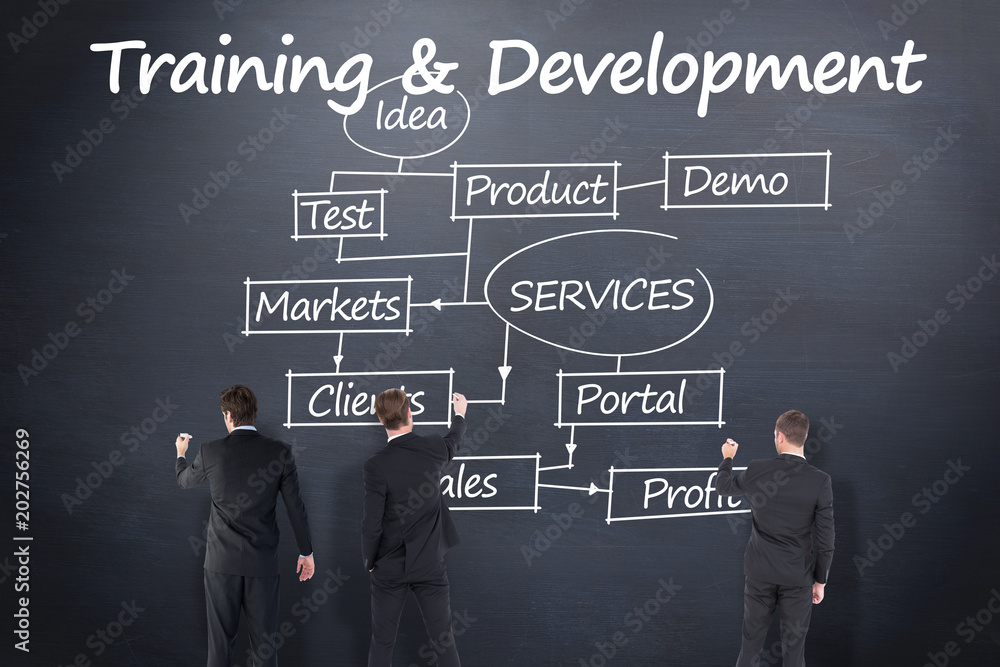 Business team writing against blackboard Business team writing against blackboard