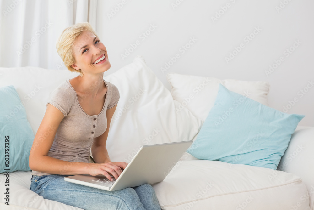 Smiling blonde woman using her laptop Smiling blonde woman using her laptop