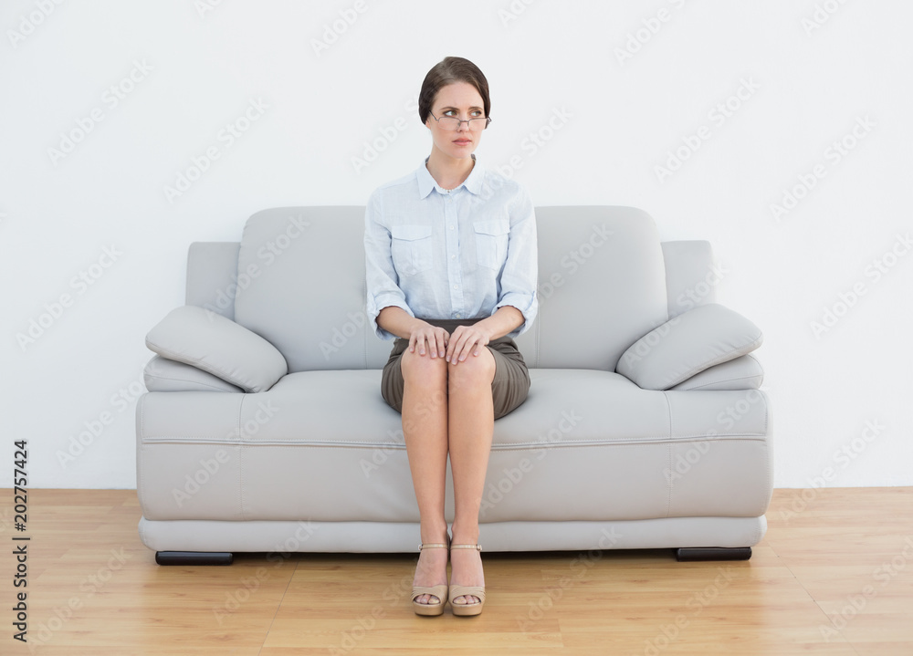 Full length of a serious well dressed woman on sofa