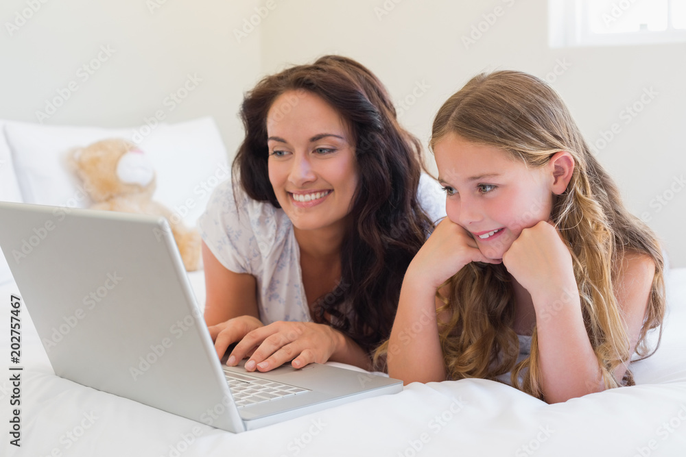 Mother and daughter using laptop in bed Mother and daughter using laptop in bed