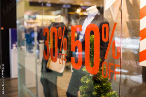 Shopping sale sign. Sign of sale shopping.discount sign on show window. Sale sign, symbol in clothes shop,The red announcement of a fifty-percentage discount on a glass show-window. Copy space photo