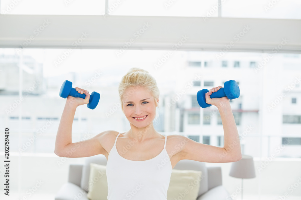 Smiling woman lifting dumbbells at fitness studio Smiling woman lifting dumbbells at fitness studio