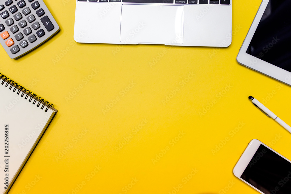 Yellow office desk table with blank notebook, tablet, calculator and ...