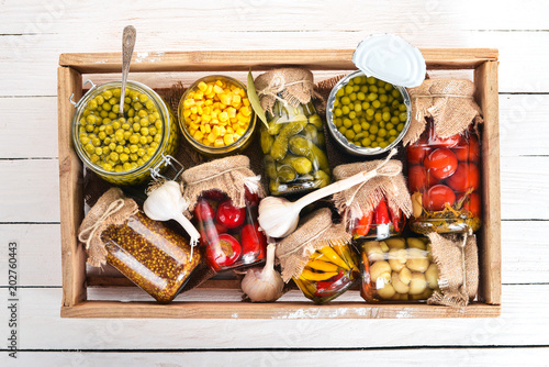 Pickled foods in cans. Stocks of food. Top view. On a wooden background. Copy space. photo