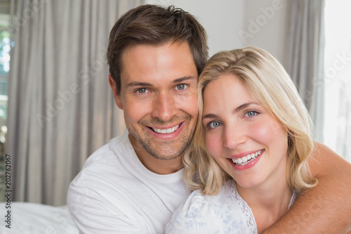 Loving man embracing woman from behind at home