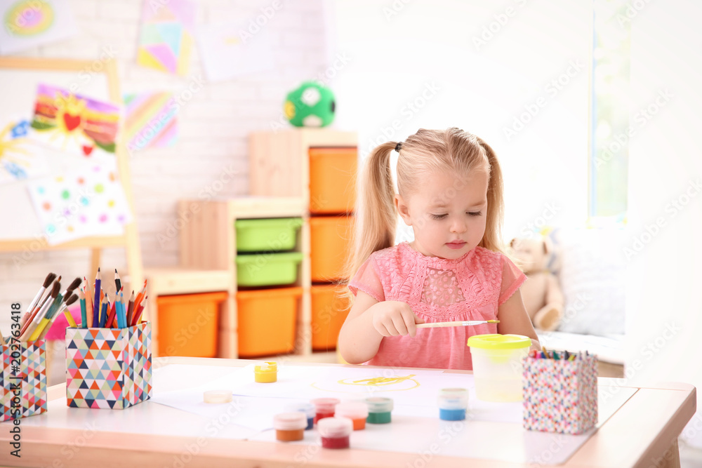 Little cute girl painting at table indoors Little cute girl painting at table indoors