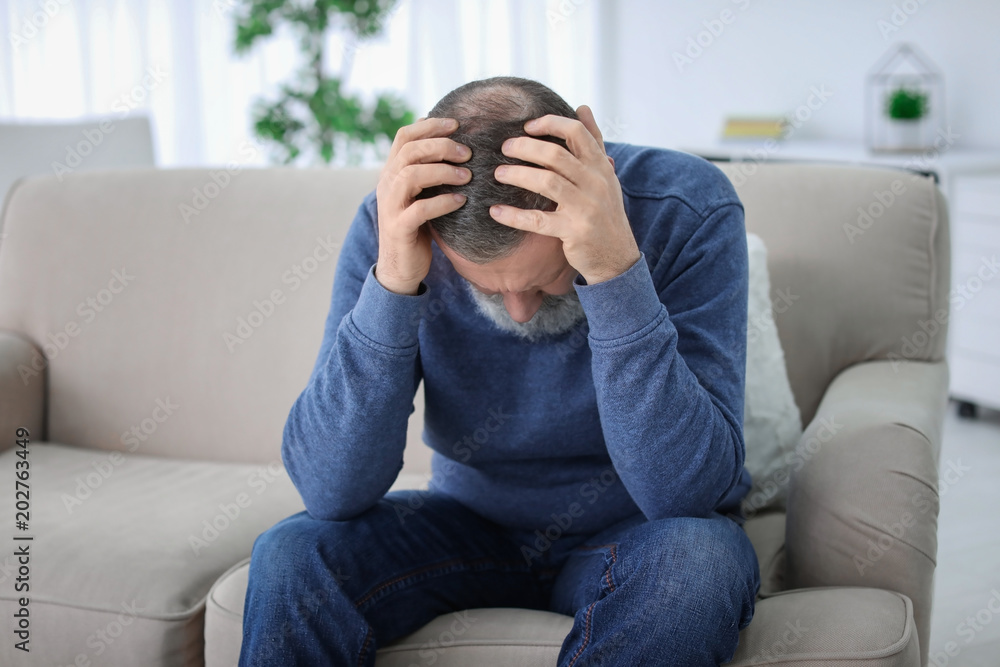 Mature man suffering from headache at home Mature man suffering from headache at home