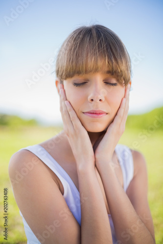 Pensive young woman posing closing eyes