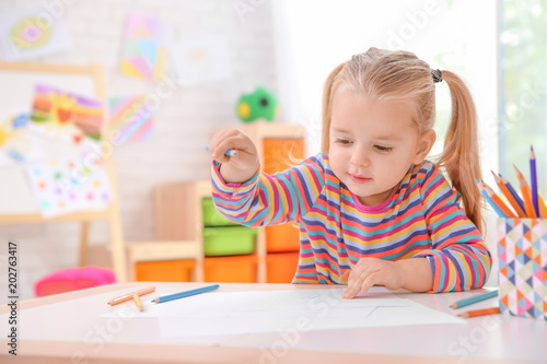 Little cute girl drawing at...