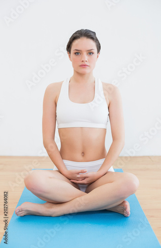 Toned woman sitting in yoga posture on exercise mat