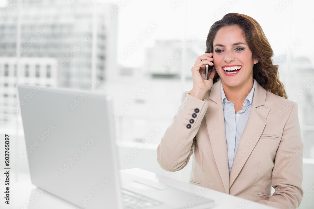 Laughing businesswoman on the phone at her desk Laughing businesswoman on the phone at her desk
