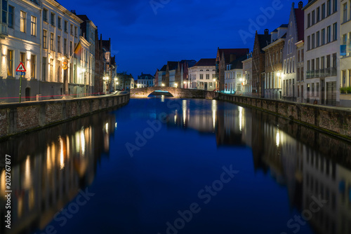 View of a canal and old historical buildings in Bruges, Belgium at dusk