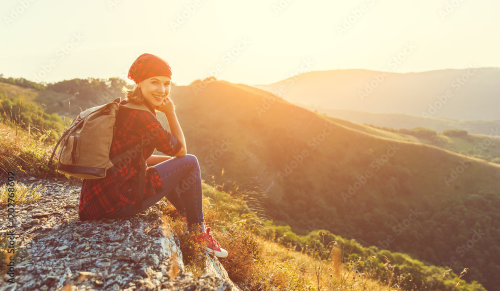 Woman tourist at top of mountain at sunset outdoors during hike in summer Woman tourist at top of mountain at sunset outdoors during hike in summer
