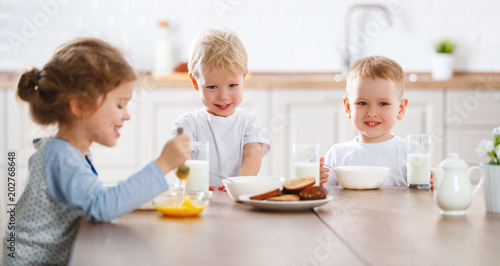 happy funny children eating breakfast