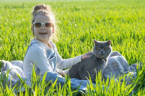 young child girl having fun with cat  cat on natural background