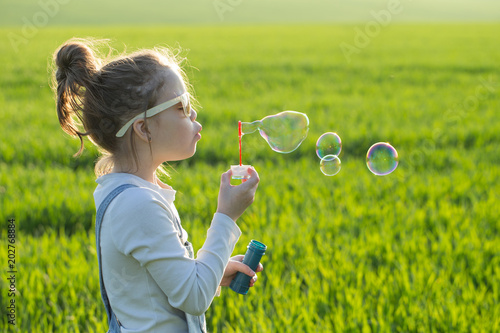 little girl is blowing a soap bubbles, Outdoor Portrait