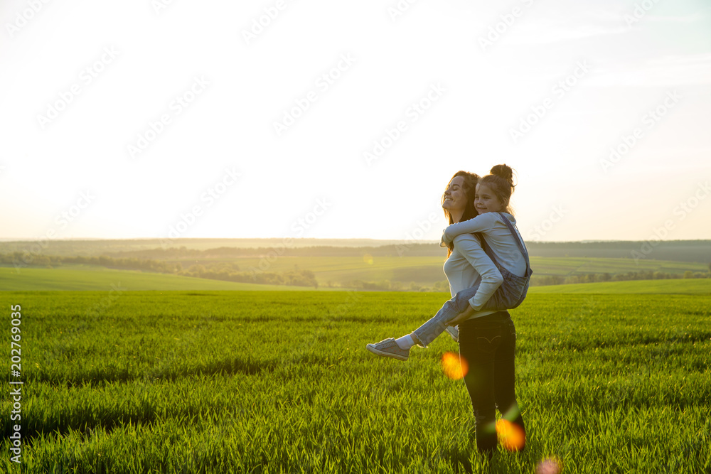 mother and daughter hugging in love playing in the park mother and daughter hugging in love playing in the park