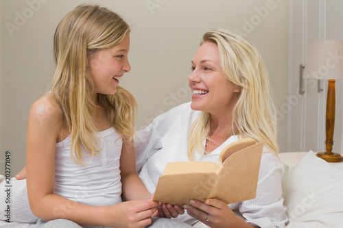 Mother and daughter with novel in bed