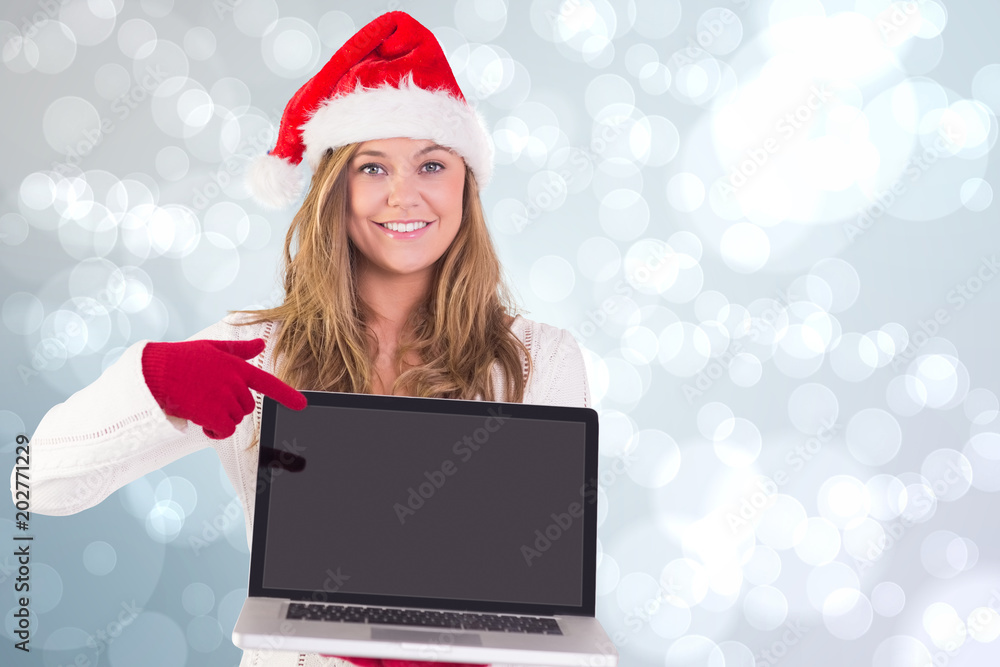 Festive blonde pointing to laptop against light glowing dots design pattern Festive blonde pointing to laptop against light glowing dots design pattern