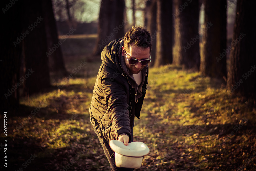 Portrait of a young men, gentleman, with a beard, hat and sunglasses, bowing; outdoor, nature Portrait of a young men, gentleman, with a beard, hat and sunglasses, bowing; outdoor, nature
