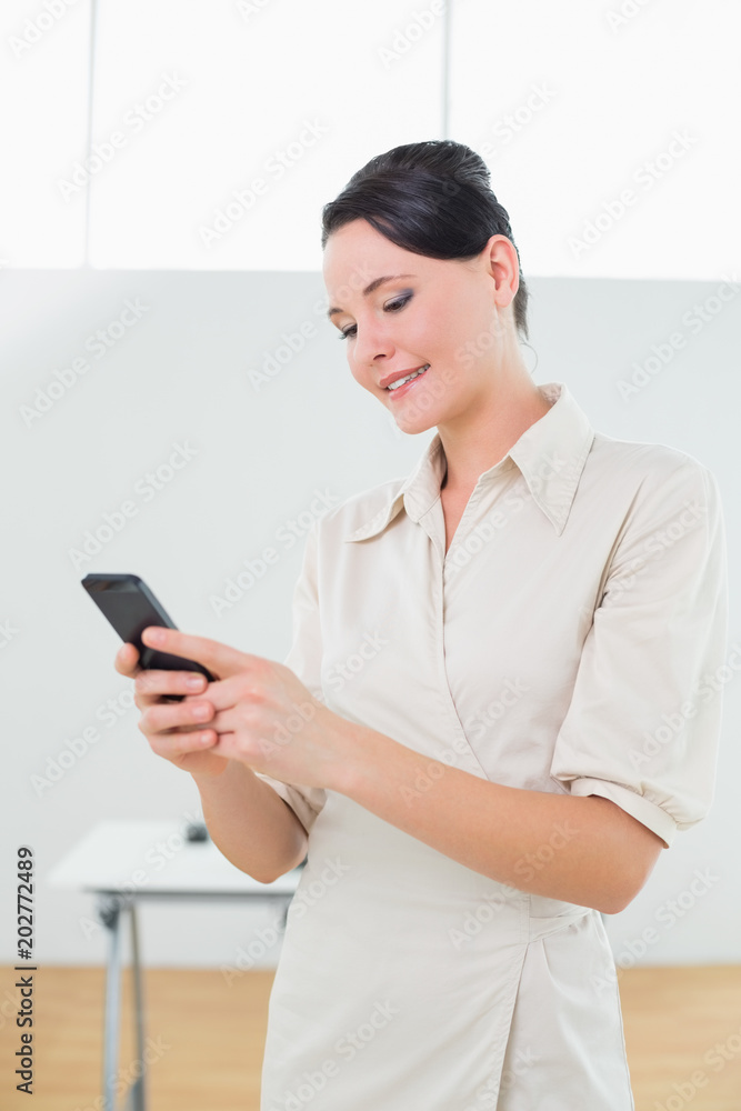 Businesswoman looking at cellphone in office Businesswoman looking at cellphone in office