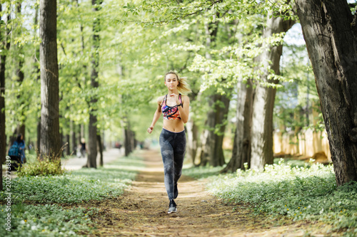Runner athlete running at cityl park. Young woman fitness jogging workout wellness concept. © F8  \ Suport Ukraine