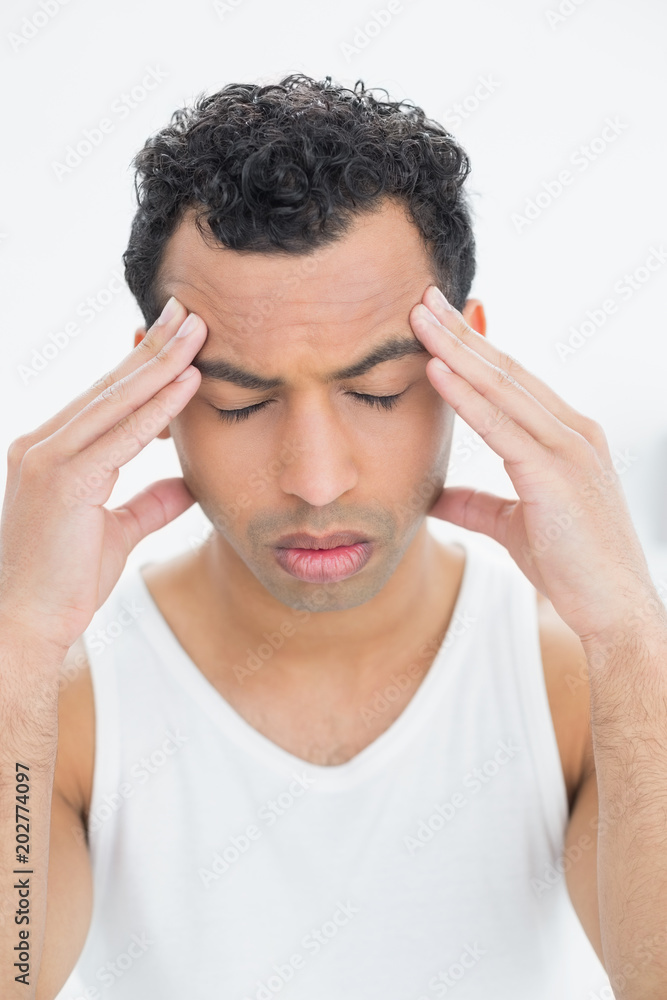 Closeup of a young man suffering from headache