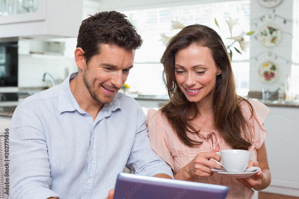 Couple using digital tablet while having coffee Couple using digital tablet while having coffee
