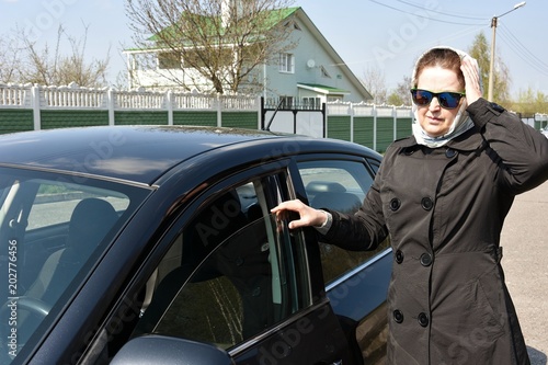 a woman is standing by the car