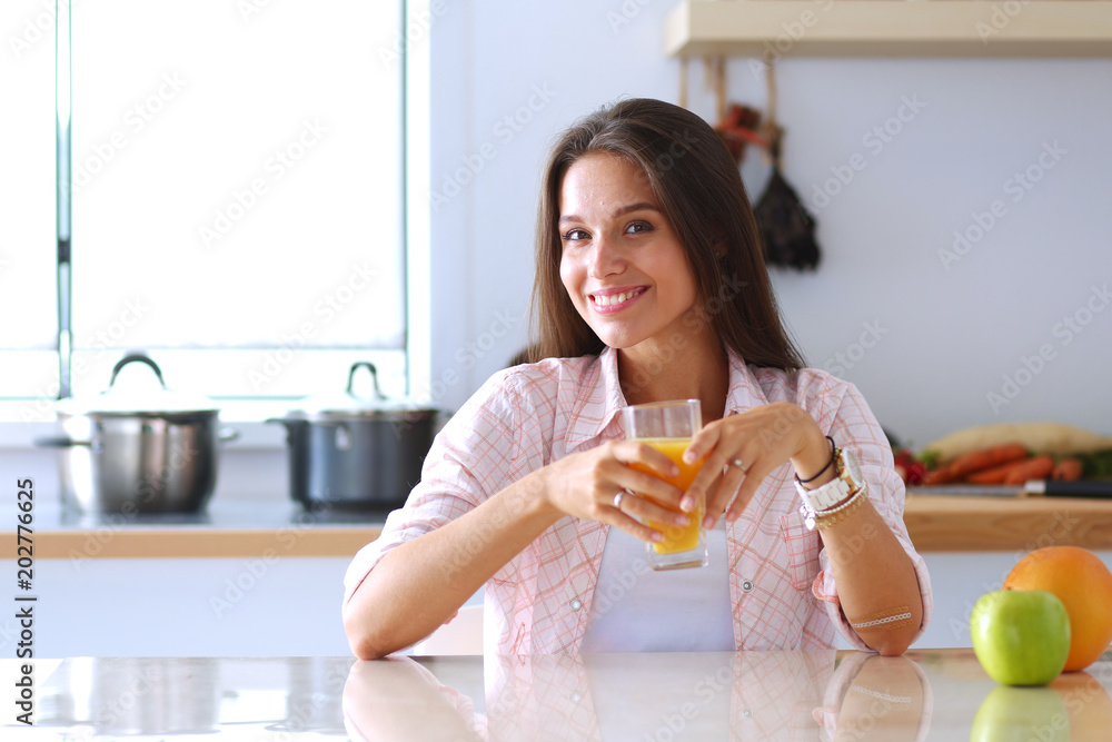 Young woman sitting a table in the kitchen. Young woman Young woman sitting a table in the kitchen. Young woman
