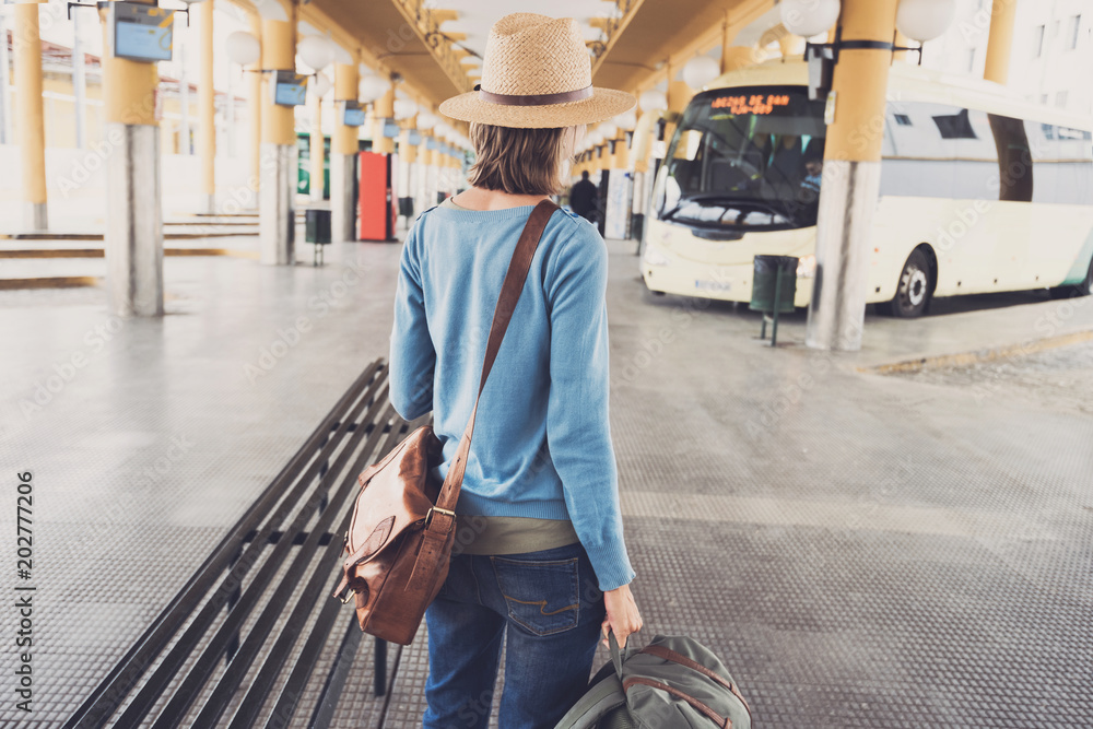 Φωτογραφία Young woman traveler waiting for a bus on a bus station, travel and active lifes