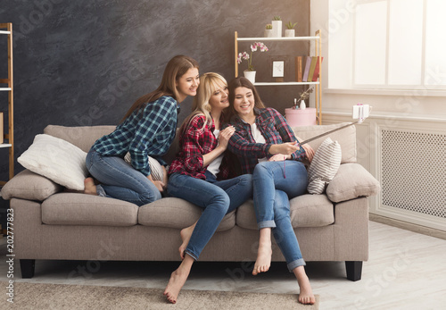 Happy friends taking selfie with smartphone photo