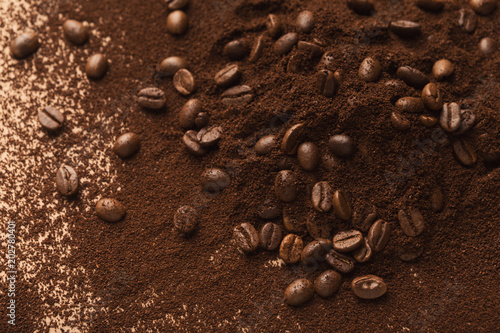 Heap of brown coffee beans and ground roasted seeds