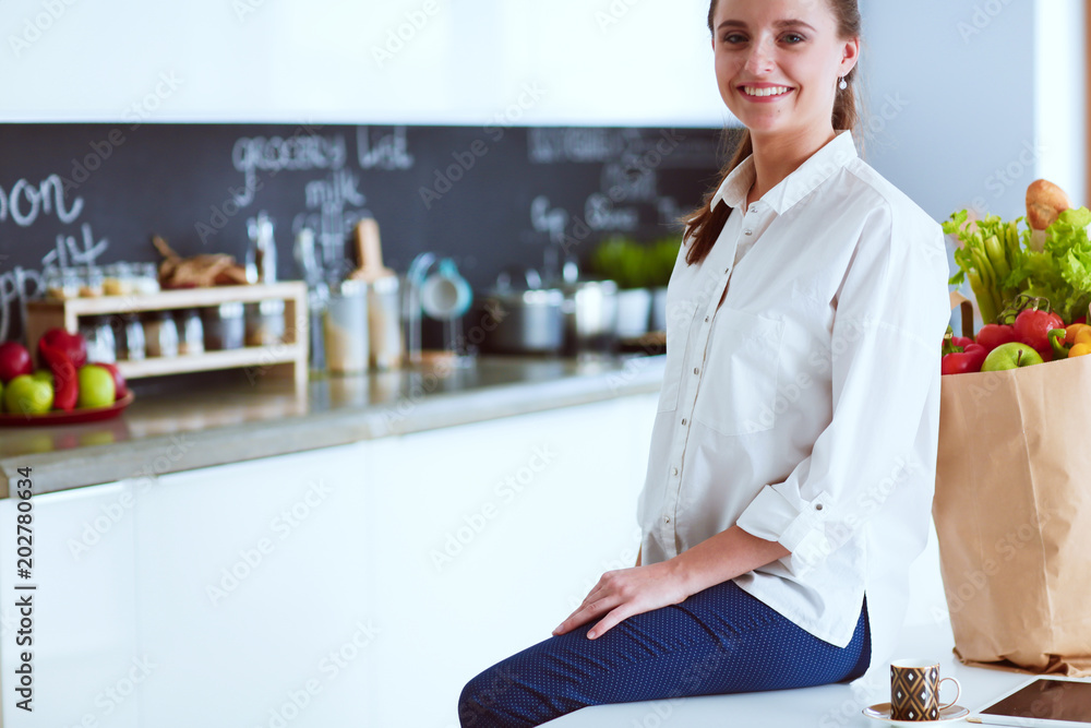 Young woman planning expenses and paying bills on her kitchen. Young woman planning expenses and paying bills on her kitchen.