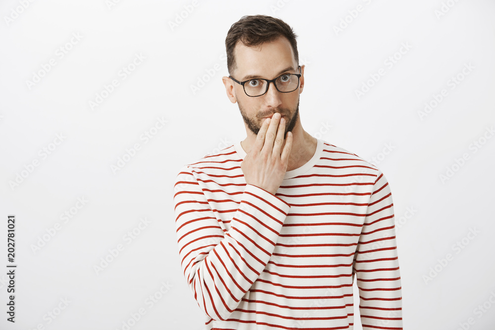 Pardon, where is my manners. Awkward embarrassed handsome male with bristle in eyewear, covering mouth and staring at camera with guilty expression, letting out someones secret accidentally Pardon, where is my manners. Awkward embarrassed handsome male with bristle in eyewear, covering mouth and staring at camera with guilty expression, letting out someones secret accidentally
