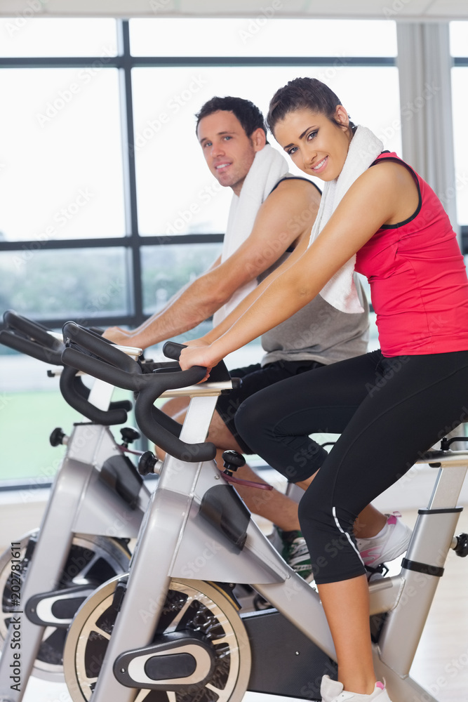 Young woman and man working out at spinning class Young woman and man working out at spinning class