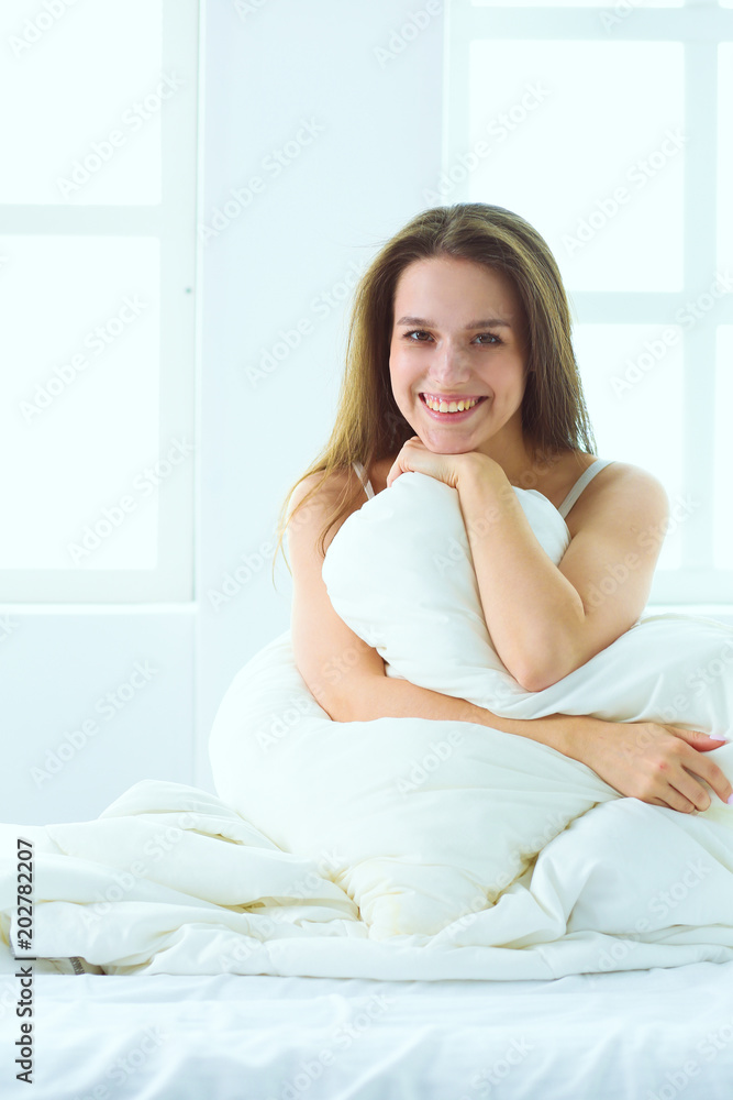 Pretty woman sitting on her bed at home Pretty woman sitting on her bed at home