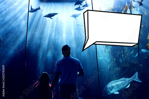 Speech bubble against father and daughter looking at fish tank