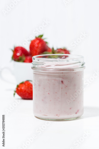 strawberry yogurt and fresh berries on a white background, vertical
