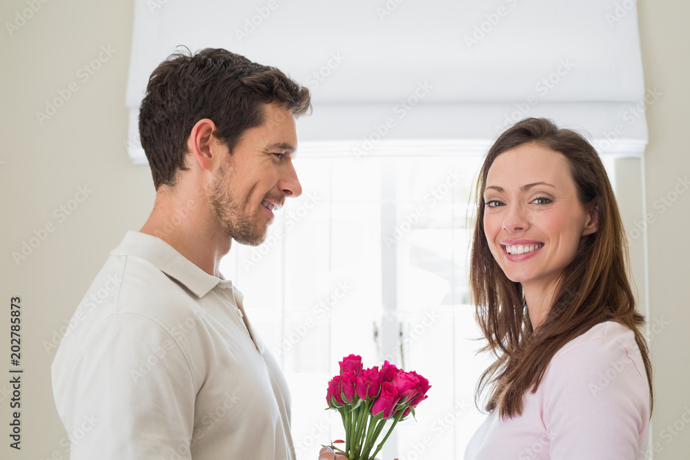 Side view of man giving happy woman flowers Side view of man giving happy woman flowers