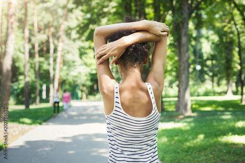 Young female runner warming up before running