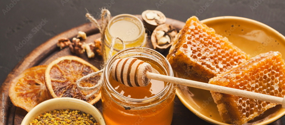 Various types of honey on wooden platter, closeup - obrazy, fototapety, plakaty 